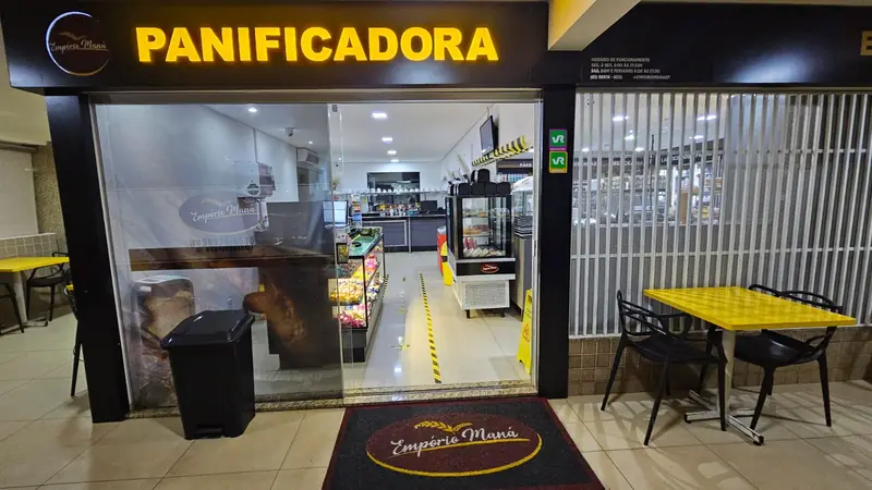 Fachada do Empório Maná Sudoeste com mesas na calçada